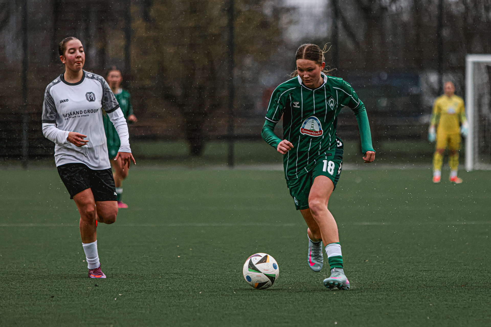 Eine U17-Spielerin im Heimtrikot mit dem Ball am Fuß.