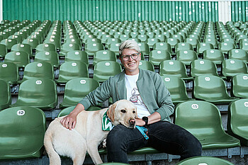 Vanessa Fischer sitzt mit ihrem Hund im Weserstadion.