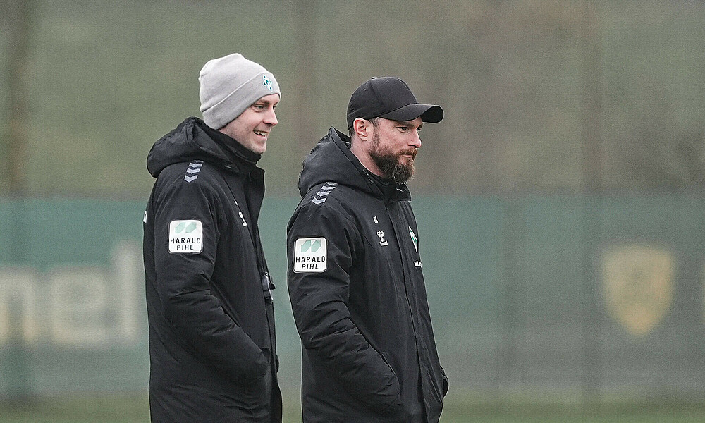 null Links Ole Werner mit grauer Wintermütze und Jacke und rechts daneben Patrick Kohlmann mit schwarzer Kappe