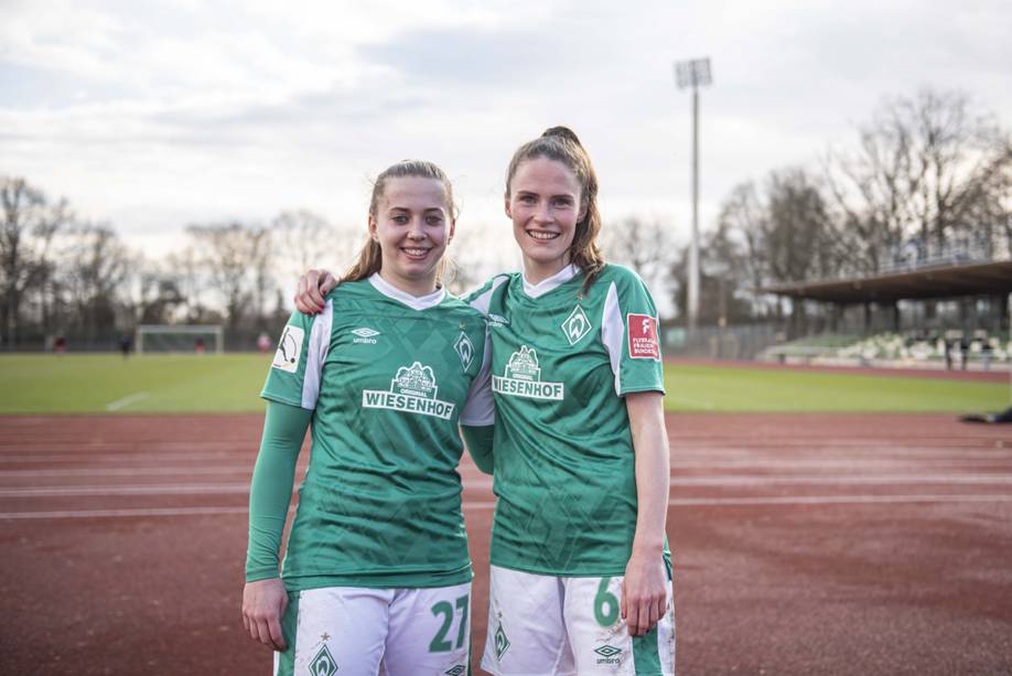 Nina Lührßen und Reena Wichmann haben sich die Arme um die Schultern gelegt und lächeln in die Kamera.