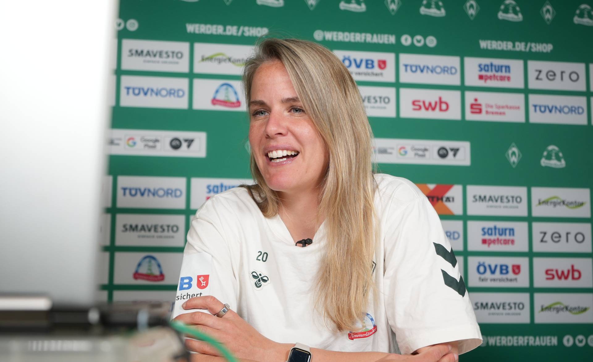 Lena Petermann schaut auf einen Laptop und spricht.