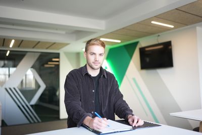 Cimo Röcker sitzt vor der Werder-Raute und unterschreibt seinen Vertrag.