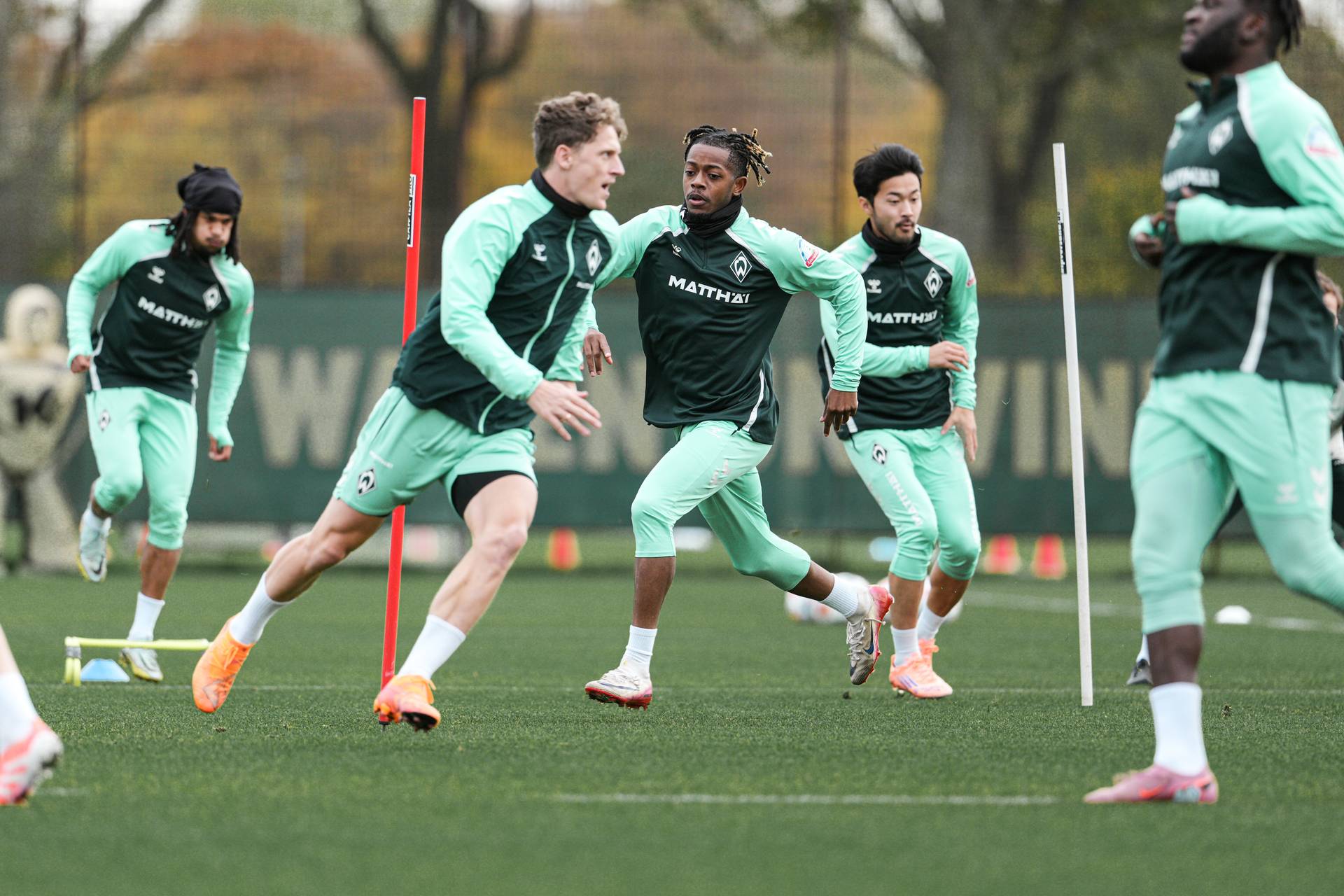 Jens Stage und Samuel Mbangula laufen über den Trainingsplatz.