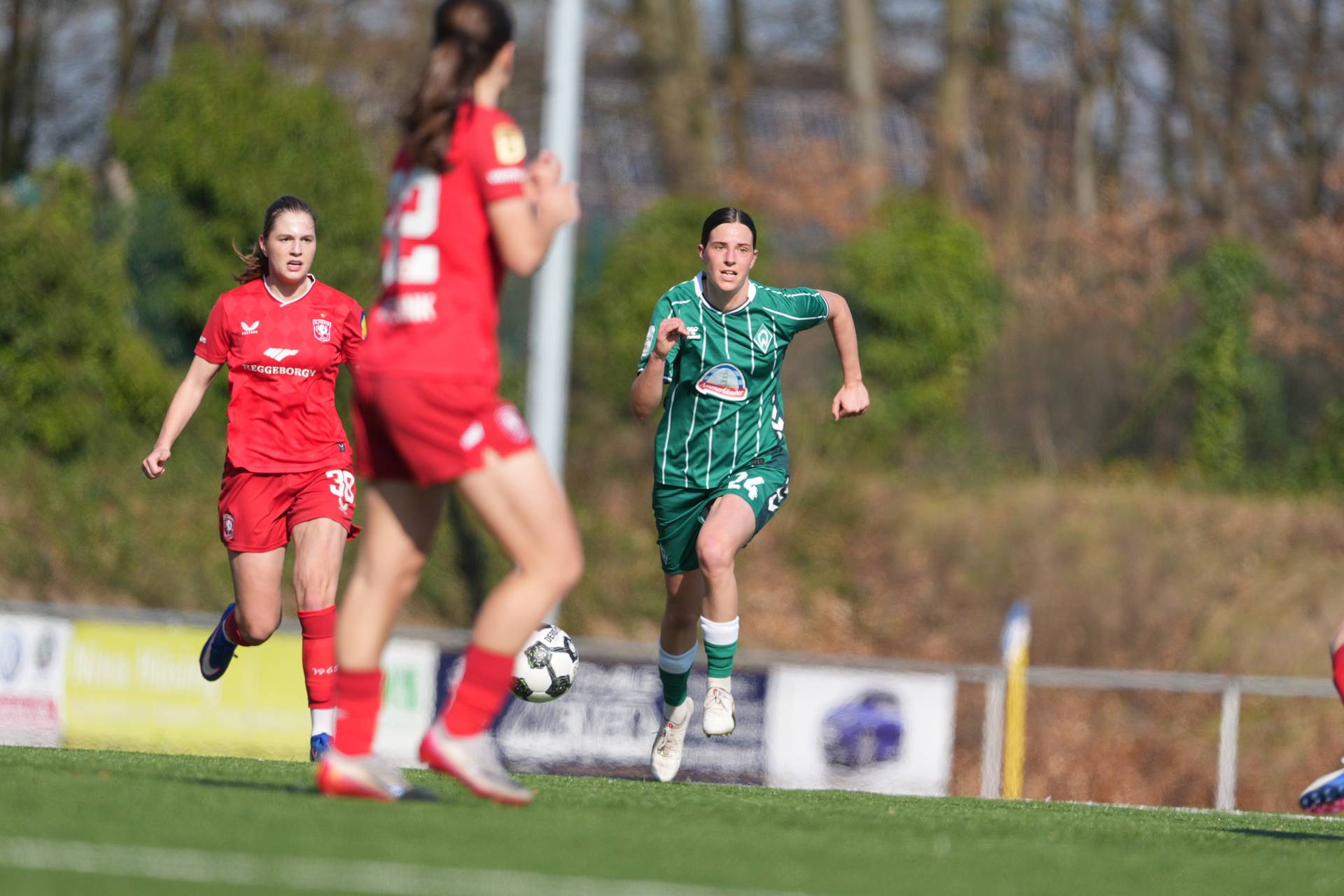 Lara Schmidt läuft mit Ball am Fuß im grünen Heimtrikot über den Platz.