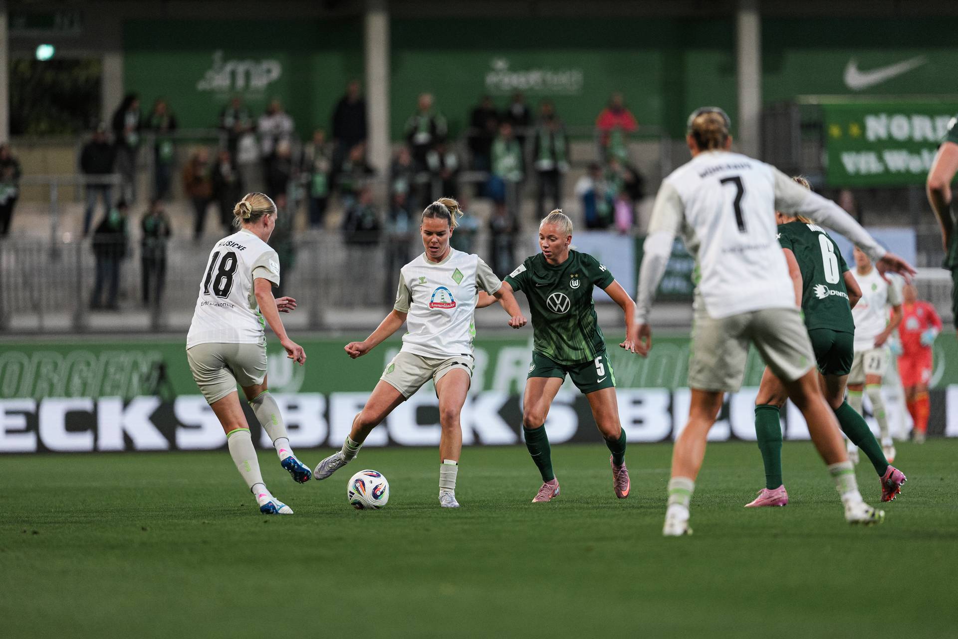 Juliane Wirtz im Hinspiel in Wolfsburg im Auswärtstrikot am Ball. Hinter ihr eine Wolfsburger Verteidigerin.