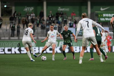 Juliane Wirtz im Hinspiel in Wolfsburg im Auswärtstrikot am Ball. Hinter ihr eine Wolfsburger Verteidigerin.