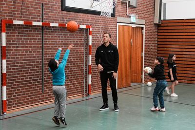 Werderspieler spielt mit Kindern Basketball