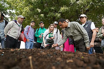 Ein Mitarbeiter zeigt der Delegation den Anbau von Baumwolle.