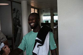 Naby Keita lächelt mit einem Handtuch über der Schulter. 