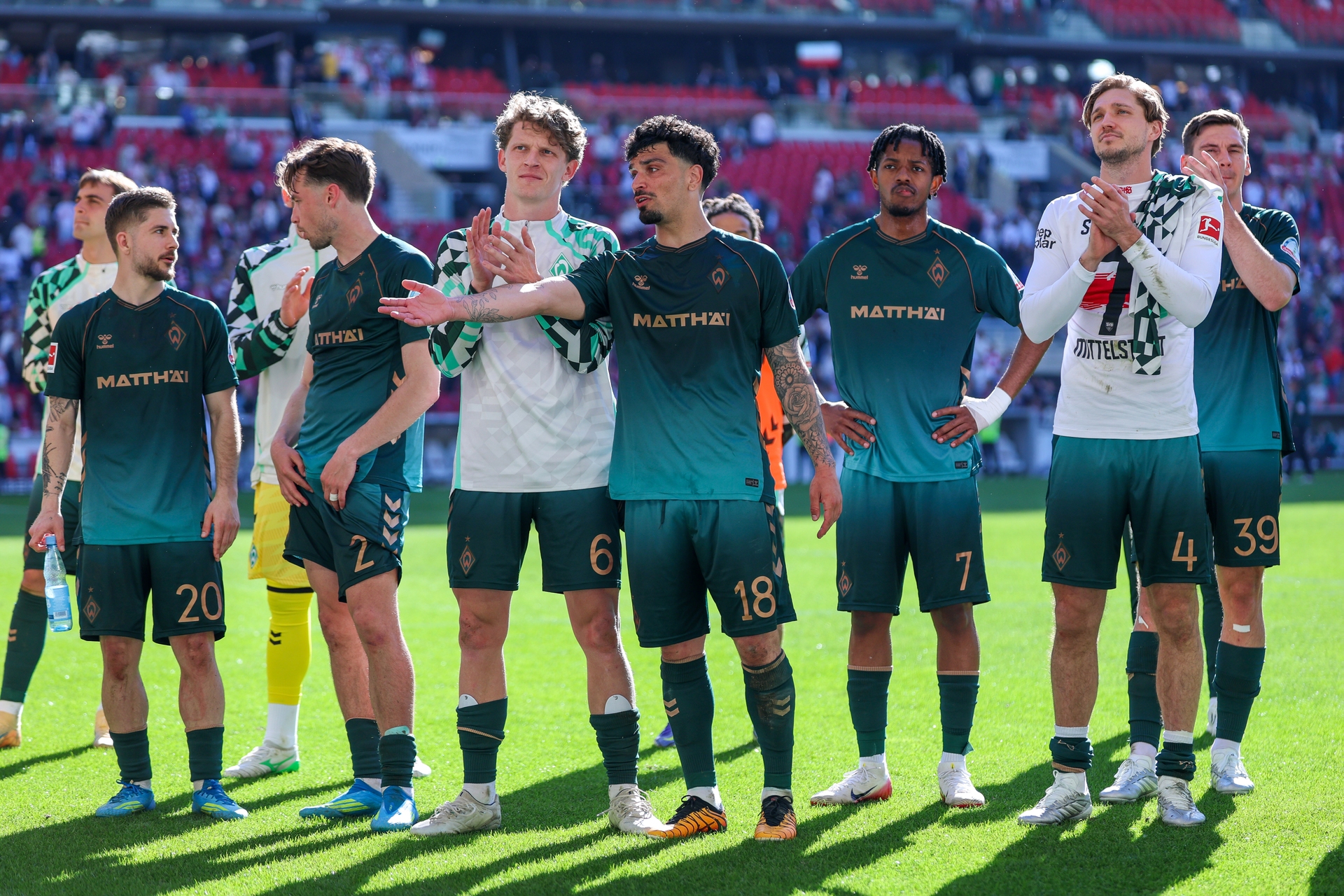 Die Mannschaft blickt in Richtung der Gästekurve und applaudiert.