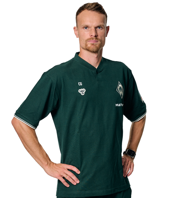 Portrait Christian Groß. Es stemmt seine Arme in die Hüften