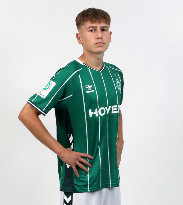 Portrait von Devin Bischel. Er stemmt die Hände in die Hüften.