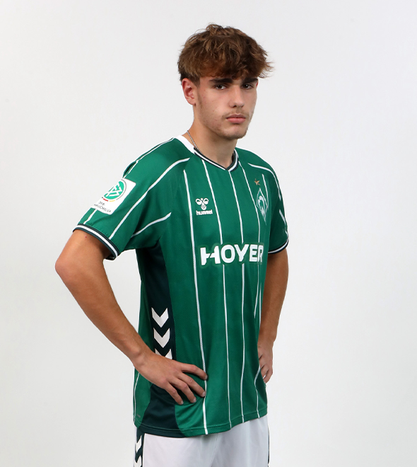 Portrait von Julian Luft. Er stemmt die Hände in die Hüften.