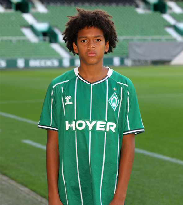 Portrait von Leon Mansaray. Er stemmt die Hände in die Hüften.