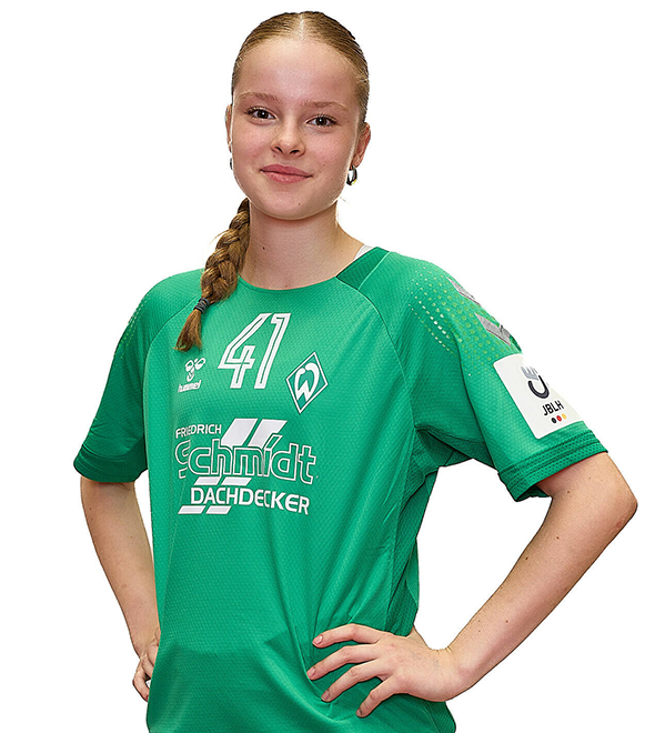 Eine junge Frau im grünen Sport-Shirt mit der Nummer 41 drauf, sie stemmt die Arme in die Hüften und lächelt.