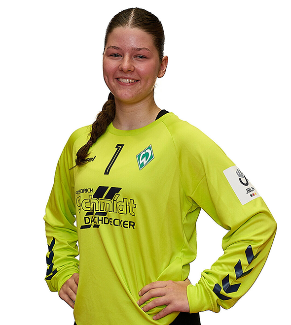 Eine junge Frau im gelben Sport-Shirt mit der Nummer 1 drauf, sie stemmt die Arme in die Hüften und lächelt.