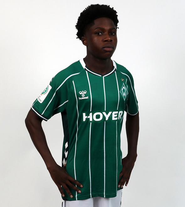 Portrait von Menson Nsiah. Er stemmt die Hände in die Hüften.