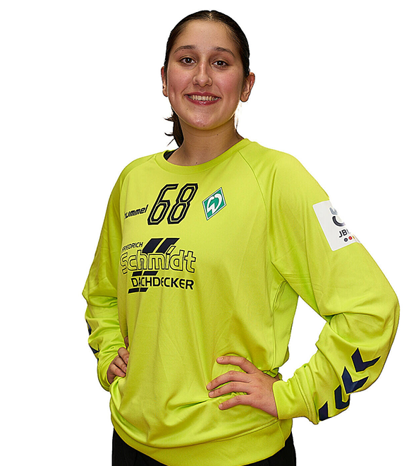 Eine junge Frau im gelben Sport-Shirt mit der Nummer 68 drauf, sie stemmt die Arme in die Hüften und lächelt.