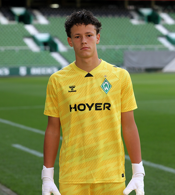 Portrait von Damian Miernik. Er stemmt die Hände in die Hüften.