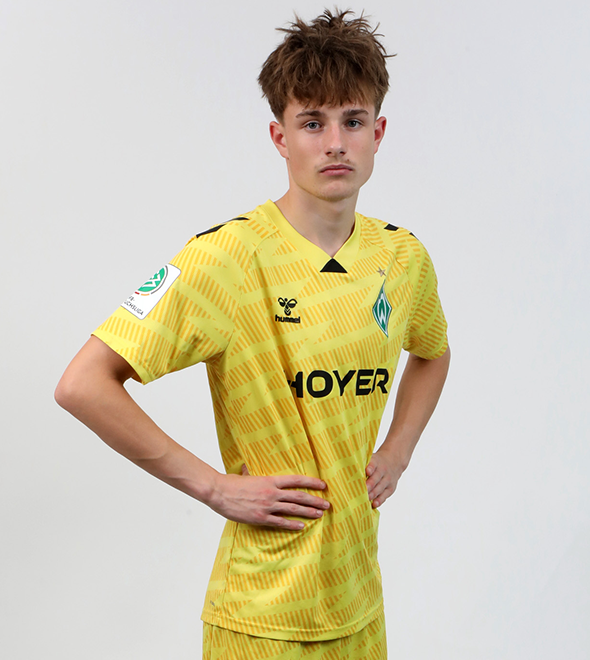 Portrait von Win Hüneke. Er stemmt die Hände in die Hüften.