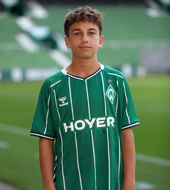 Portrait von Leonard Oster. Er stemmt die Hände in die Hüften.