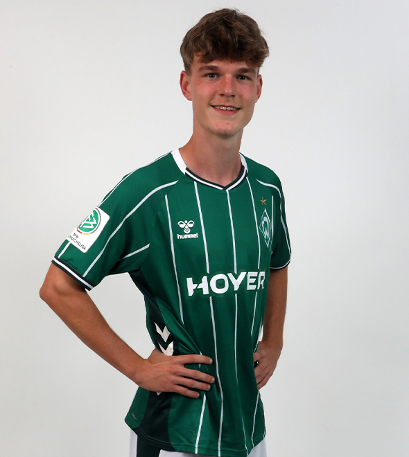 Portrait von Jannes Ossadnik. Er stemmt die Hände in die Hüften.