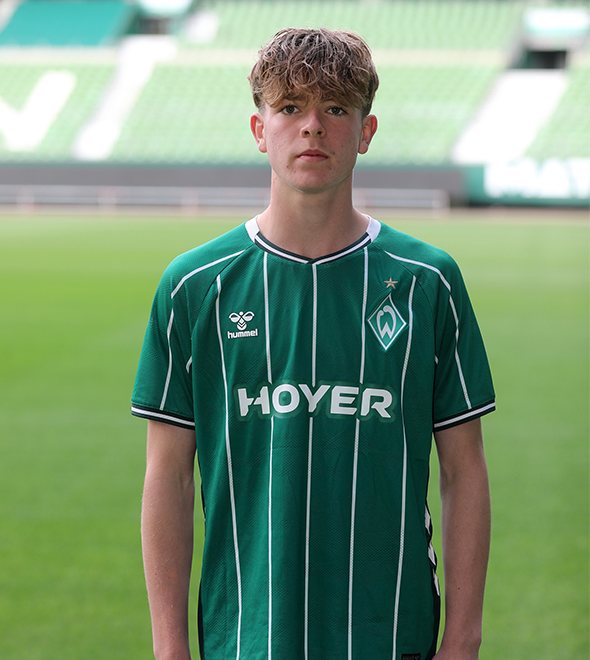 Portrait von Tom Lasse Hollmeyer. Er stemmt die Hände in die Hüften.