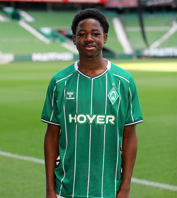 Portrait von Dieumerci Bolm-Sima. Er stemmt die Hände in die Hüften.