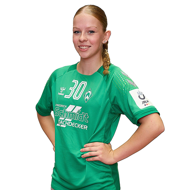 Eine junge Frau im grünen Sport-Shirt mit der Nummer 30 drauf, sie stemmt die Arme in die Hüften und lächelt.