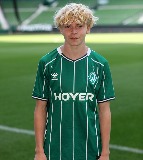 Portrait von Milow Hoeder. Er stemmt die Hände in die Hüften.