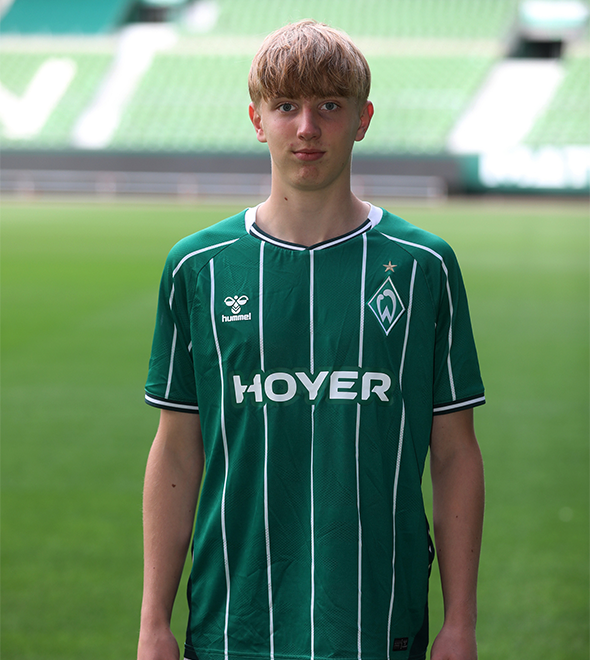 Portrait von Jan Lange. Er stemmt die Hände in die Hüften.