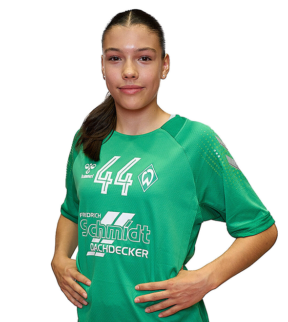 Eine junge Frau im grünen Sport-Shirt mit der Nummer 44 drauf, sie stemmt die Arme in die Hüften und lächelt.