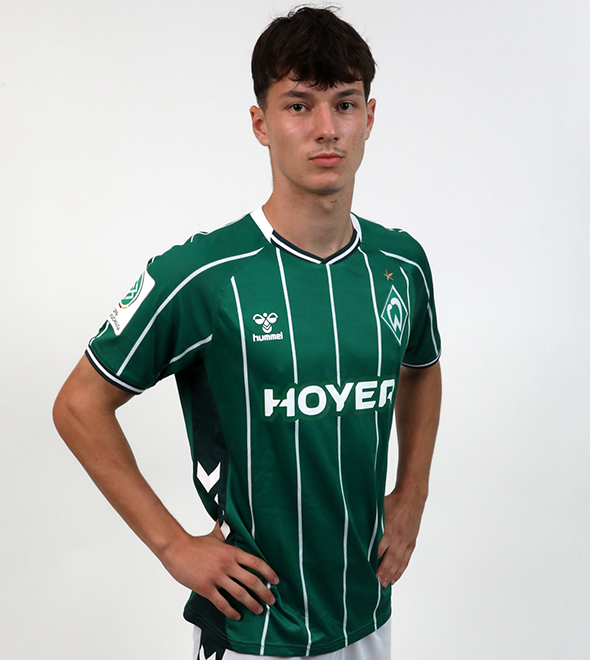 Portrait von Tom Kaperkon. Er stemmt die Hände in die Hüften.