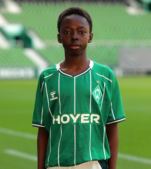 Portrait von Bryan Owusu. Er stemmt die Hände in die Hüften.