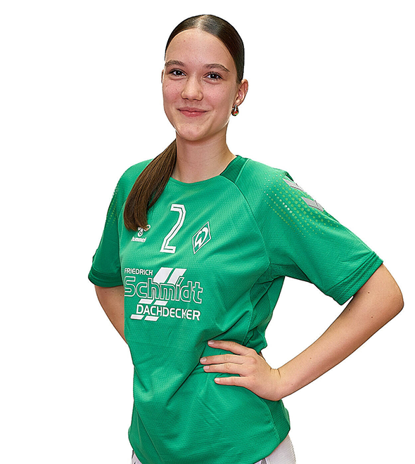 Eine junge Frau im grünen Sport-Shirt mit der Nummer 2 drauf, sie stemmt die Arme in die Hüften und lächelt.