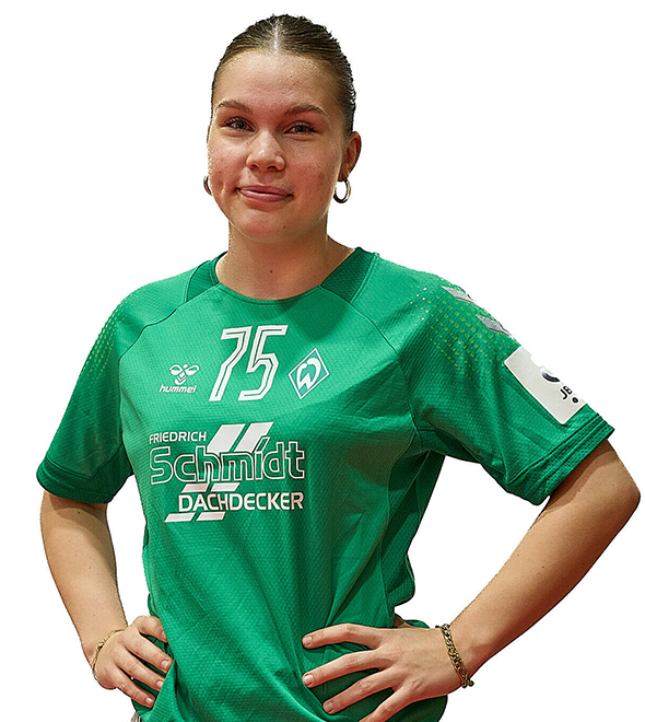 Eine junge Frau im grünen Sport-Shirt mit der Nummer 75 drauf, sie stemmt die Arme in die Hüften und lächelt.