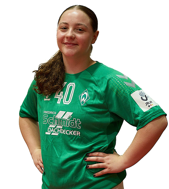 Eine junge Frau im grünen Sport-Shirt mit der Nummer 40 drauf, sie stemmt die Arme in die Hüften und lächelt.