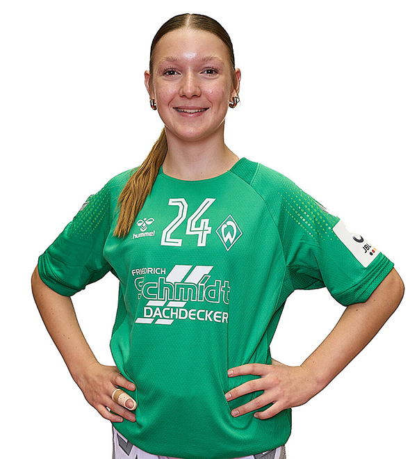 Eine junge Frau im grünen Sport-Shirt mit der Nummer 24 drauf, sie stemmt die Arme in die Hüften und lächelt.