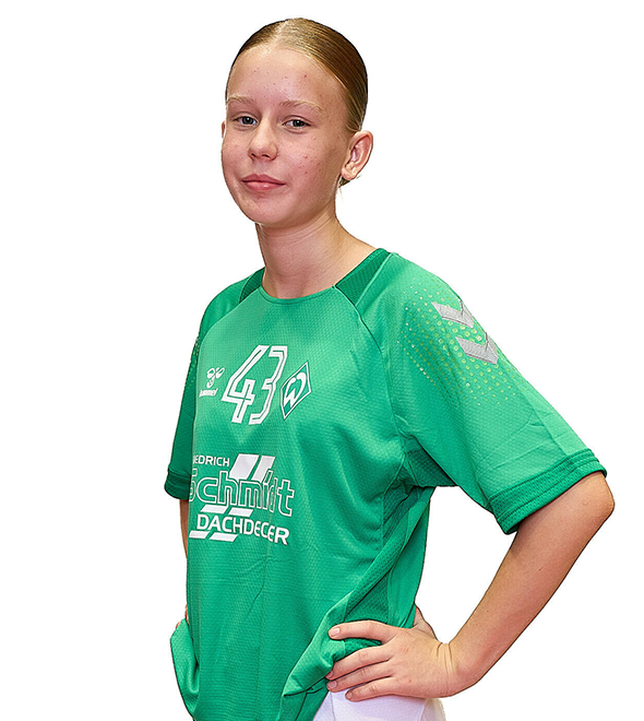 Eine junge Frau im grünen Sport-Shirt mit der Nummer 43 drauf, sie stemmt die Arme in die Hüften und lächelt.