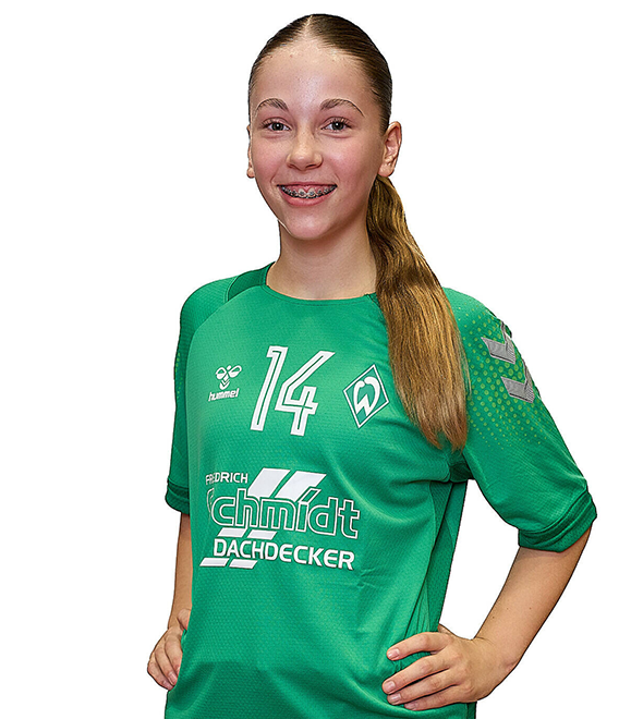 Eine junge Frau im grünen Sport-Shirt mit der Nummer 14 drauf, sie stemmt die Arme in die Hüften und lächelt.