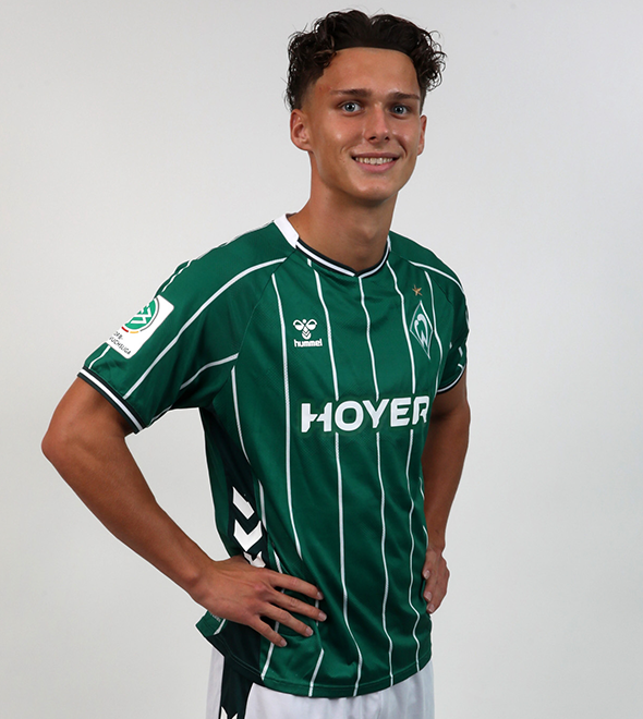 Portrait von Kevin Manthey. Er stemmt die Hände in die Hüften.