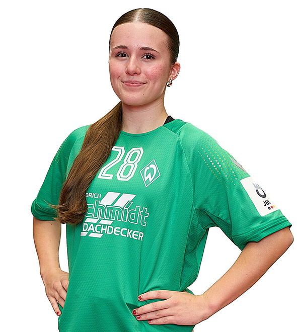 Eine junge Frau im grünen Sport-Shirt mit der Nummer 28 drauf, sie stemmt die Arme in die Hüften und lächelt.