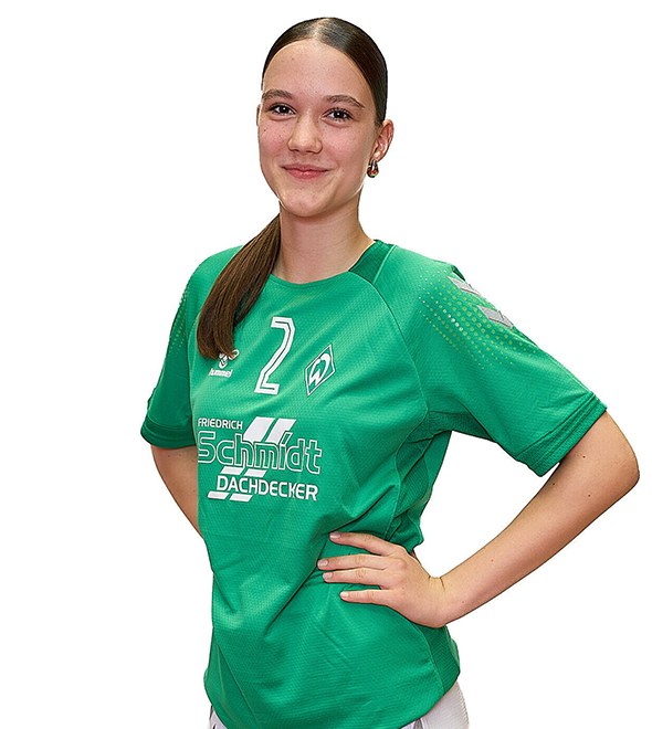 Eine junge Frau im grünen Sport-Shirt mit der Nummer 2 drauf, sie stemmt die Arme in die Hüften und lächelt.
