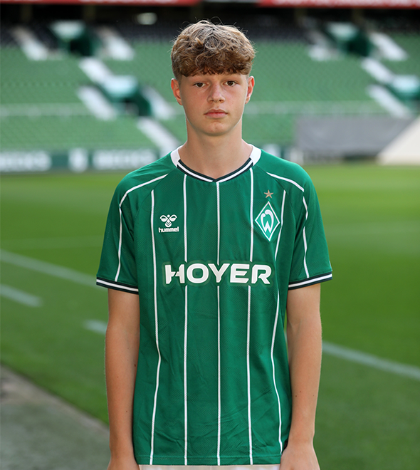 Portrait von Noah Adeberg. Er stemmt die Hände in die Hüften.