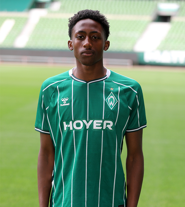 Portrait von Jerry Oguns. Er stemmt die Hände in die Hüften.