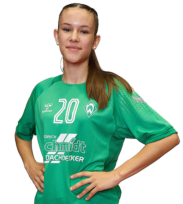 Eine junge Frau im grünen Sport-Shirt mit der Nummer 20 drauf, sie stemmt die Arme in die Hüften und lächelt.
