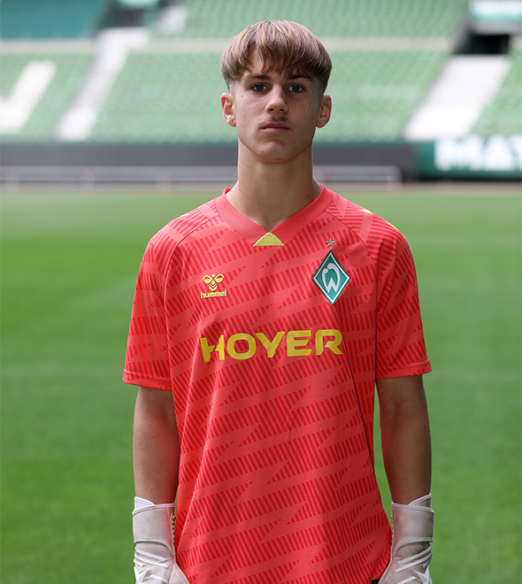 Portrait von Max Lübitz. Er stemmt die Hände in die Hüften.