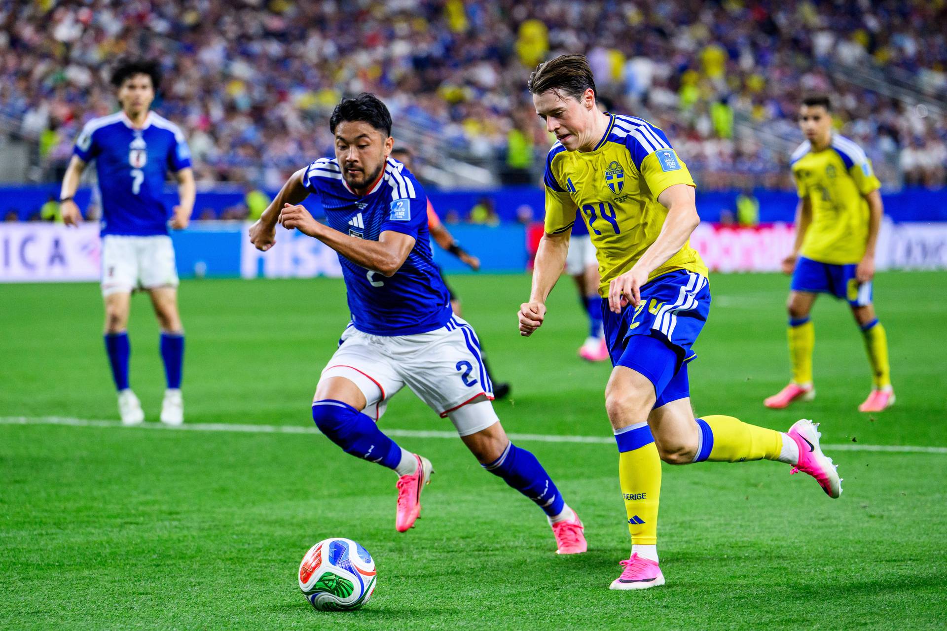 Yukinari Sugawara im blauen Trikot der japanischen Nationalmannschaft. Er geht in einen Zweikampf mit einem Schweden.