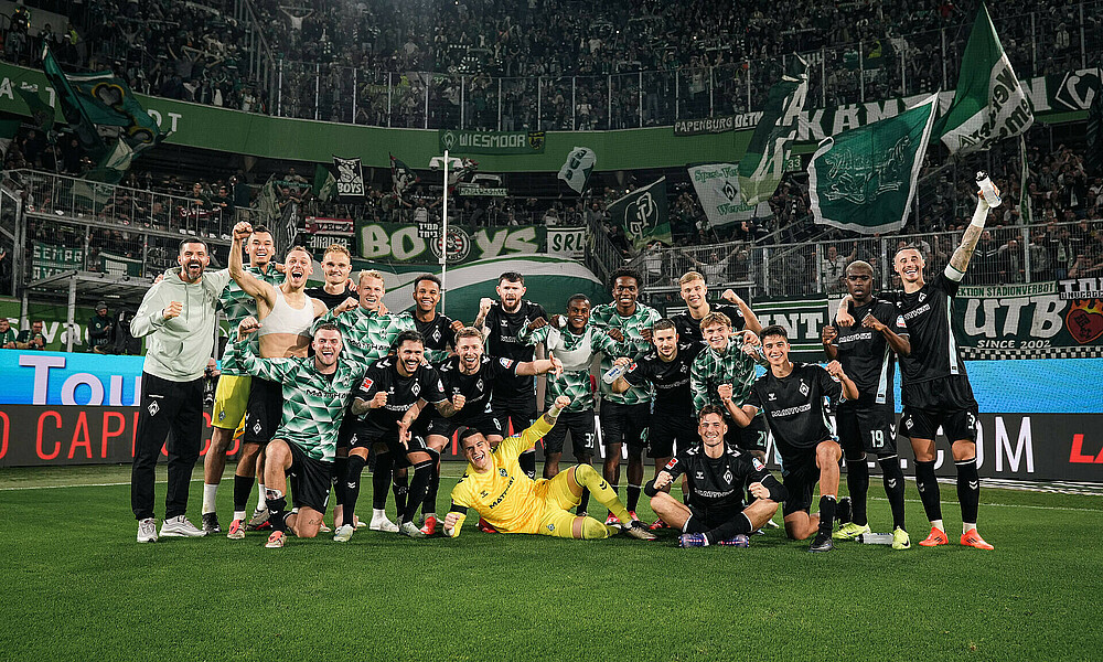 Die Mannschaft posiert vor der Gästekurve. 