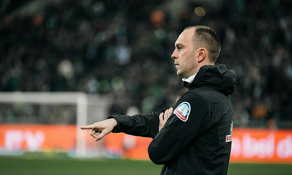 Ole Werner zeigt mit dem Zeigefinger auf etwas